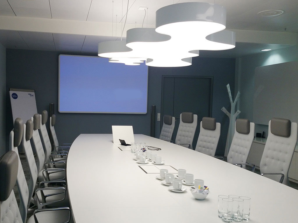 Conference table with integrated projector. Additional integrated connection panels for media controls, playback devices, etc.