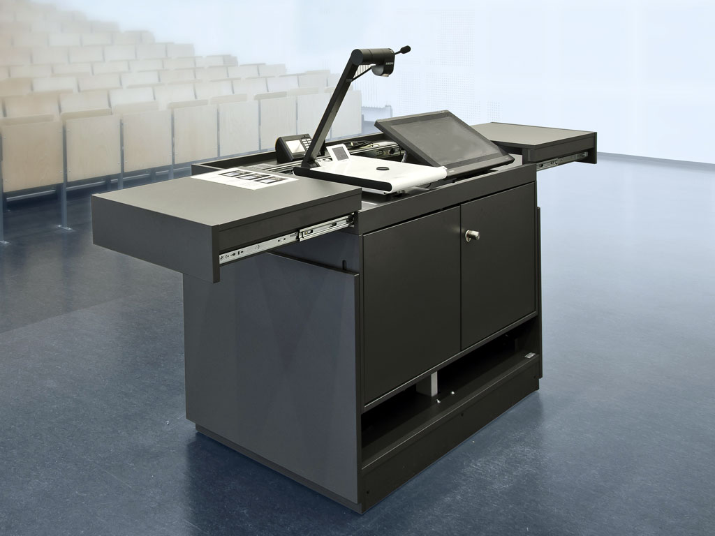 Lecture hall lectern teach.duo with open drawers, including interactive display, visualiser and media control. Closed revision doors.