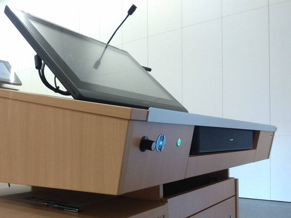 Detailed view of lectern height adjustment, Bose soundbar and interactive display.