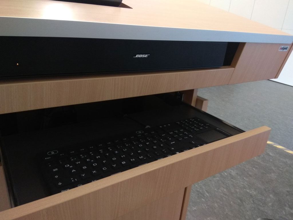 Detailed view of Bose soundbar, keyboard drawer below.